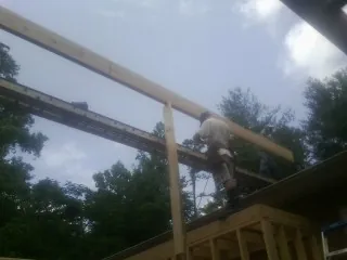Carpenter setting a ridge beam over a new addition frame — Ice Dam Removal by Roofing Brothers in Dilworth
