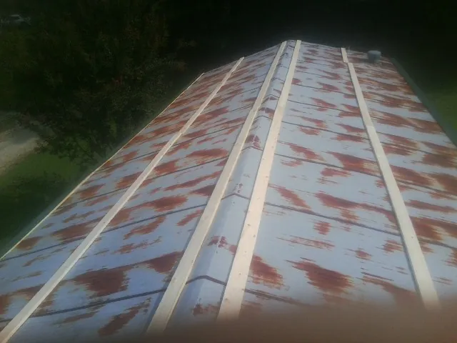 Rusted metal roof panels with new wood purlins before replacement — Storm Damage Roof Repair in Dilworth by Roofing Brothers