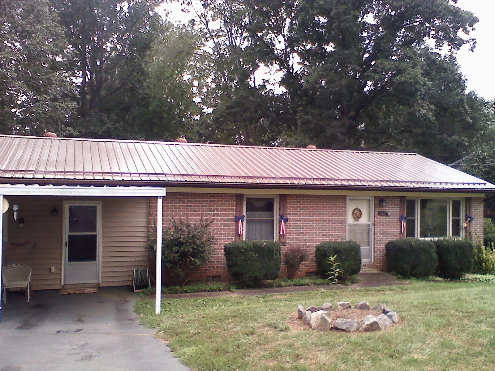 Bronze metal roof and carport on a brick ranch home — Roof Repair work by our crew in Dilworth